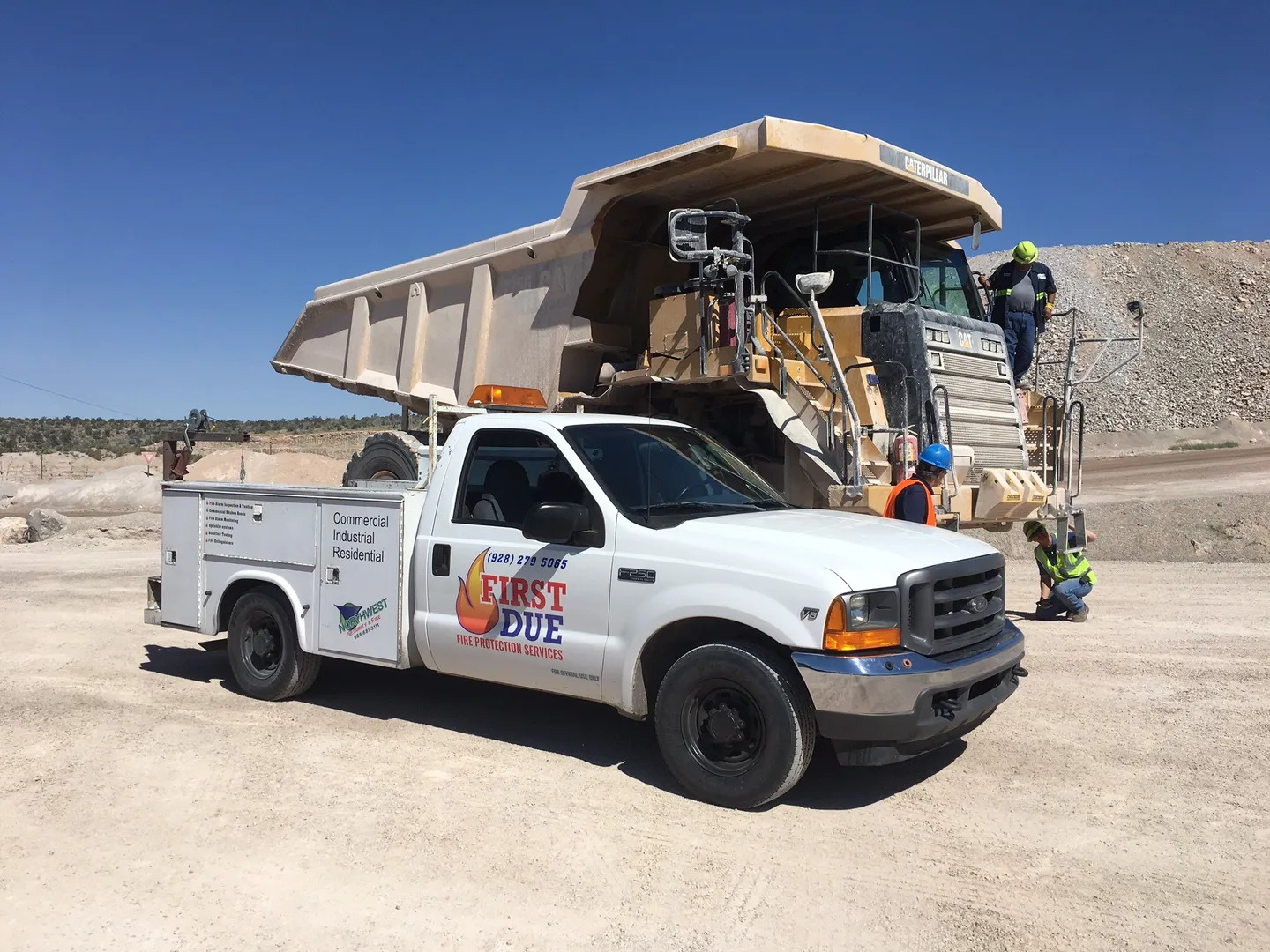 A white truck with a man standing on top of it.