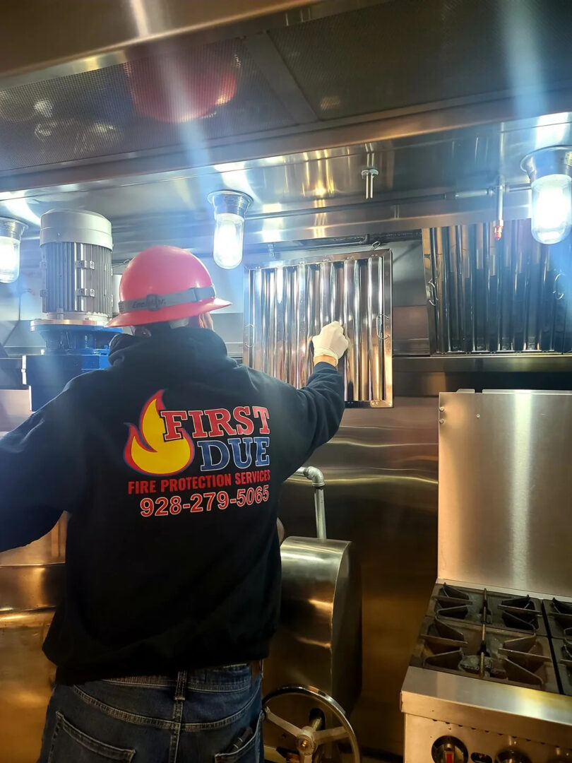 A person in a hard hat cooking food.