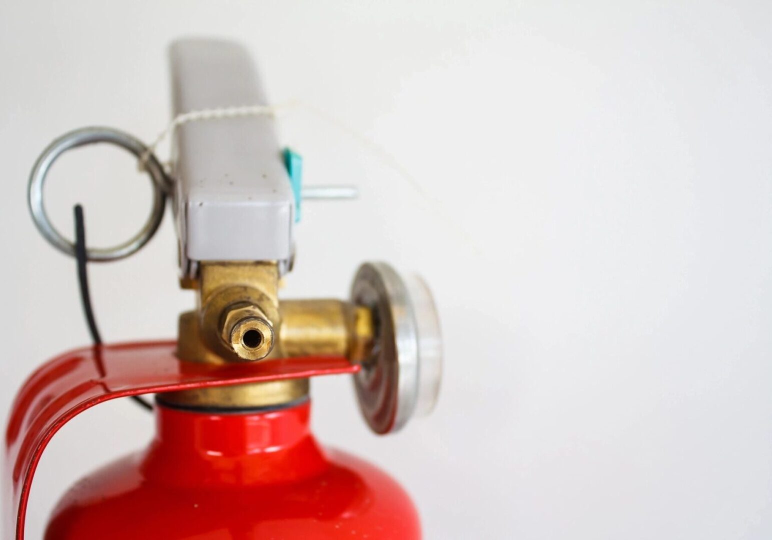 A close up of the fire extinguisher on a white wall